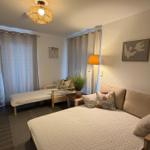 Ein Schlafzimmer mit Bett, Sofa, Lampe und Gardinen.