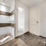 Dusche mit Regenduschkopf und Badewanne im modernen Badezimmer.