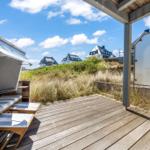 Terrasse mit Strandkorb und Blick auf Dünen und Häuser