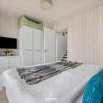 Schlafzimmer mit Bett, Kleiderschrank und Fernseher an der Wand.