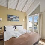 Schlafzimmer mit Doppelbett, Fenster und Holzboden.