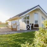 Ein Haus mit Terrasse, Strandkorb und Garten.