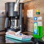 Küchenzeile mit Kaffeemaschine, Spülmittel und Handtuch auf Arbeitsfläche.