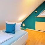 Bedroom with sloped ceiling, bed, nightstand, and radiator.