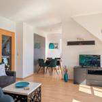 Living and dining area with TV, table, chairs, and blue decor.