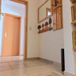 Entrance area with wooden mirrors, shoe rack, and steps.