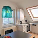 Kitchen with dining area, skylight, and modern lighting.