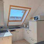 Kitchen with skylight, sink, stove, and microwave.