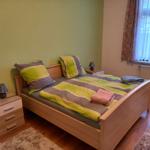 Ein Schlafzimmer mit Bett, Nachttisch und Fenster.