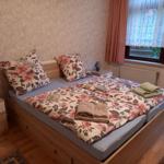 Schlafzimmer mit Doppelbett, floraler Bettwäsche und zwei Nachttischen.