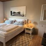 Schlafzimmer mit Doppelbett, Nachttisch, Spiegelschrank und Wandbild.