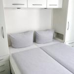 Bedroom with double bed, white wardrobes, and pillows.