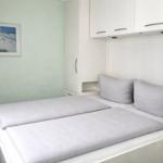 Bedroom with double bed, white wardrobes, and wall picture