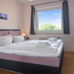 Schlafzimmer mit Bett, Fenster und Badewanne