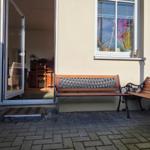 Terrace with two benches, entrance door, and view into the house.