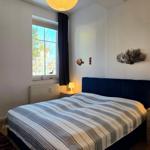Bedroom with bed, two windows, and nightstands with lamps.