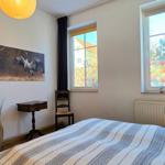 Bedroom with bed, wardrobe, and windows with colorful glass panels.