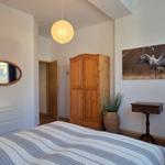 Bedroom with bed, wooden wardrobe, and wall picture of a crane.