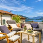 Terrace with seating and view of lake and mountains.