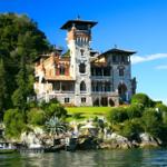 Castle-like villa by the lakeside with terrace and boat dock.