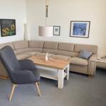 Living room with corner sofa, dining table, and wall art.
