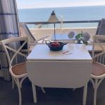 Dining area with table, chairs, and sea view