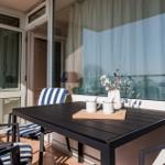 Terrace with table, chairs, and vase. Entrance to the apartment.