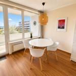 Dining room with round table, four chairs, and large window to terrace.