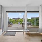 Wohnbereich mit Blick auf Terrasse und Garten. Moderne Einrichtung und helles Interieur.