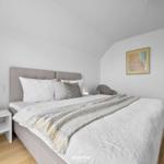 Schlafzimmer mit Bett, Nachttisch und Bild an der Wand.