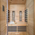 Infrarot-Sauna mit Holzverkleidung, Sitzbank und Handtuch.