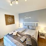 Schlafzimmer mit Bett, Nachttischen und Wanddekoration.