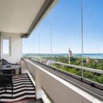 Balcony with seating area and view of lake and city
