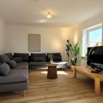 Großes Wohnzimmer mit Sofalounge und Smart-TV
