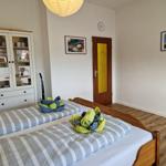 Schlafzimmer mit Doppelbett, Schrank und Tür mit gelbem Glas