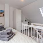Schlafzimmer mit Dachschrägen, Bett, Kleiderzimmer und Dachfenster.
