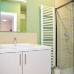 Badezimmer mit Dusche, Waschbecken und Spiegel
