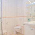 Badezimmer mit Dusche, Toilette und Waschbecken mit Spiegel.