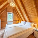Bedroom with sloped ceiling, bed, nightstand, and window