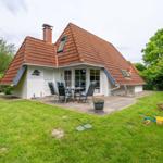 House with terrace, garden, and toys. Roof with tiles and window front.