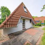 House with red tiled roof, white walls, and front garden