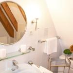Badezimmer mit Spiegel, Waschbecken und Handtuchhalter