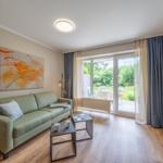 Wohnzimmer mit Sofa, Tisch und Blick auf die Terrasse.