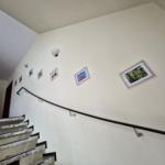 Treppe mit Geländer und Bildern an der Wand.