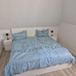 Schlafzimmer mit Doppelbett, zwei Nachttischen und Lampen.