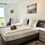 Bedroom with double bed, nightstand, and window view of green field.