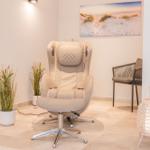 Massagesessel mit Fußstütze, Pflanzen und Wandbild im Raum.