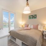 Schlafzimmer mit Bett, Fernseher und Fenster zur Aussicht