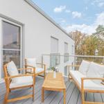 Terrasse mit Holzmöbeln und Blick auf Bäume