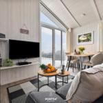 Wohnzimmer mit TV, Sofa, Esstisch und Blick auf Balkon